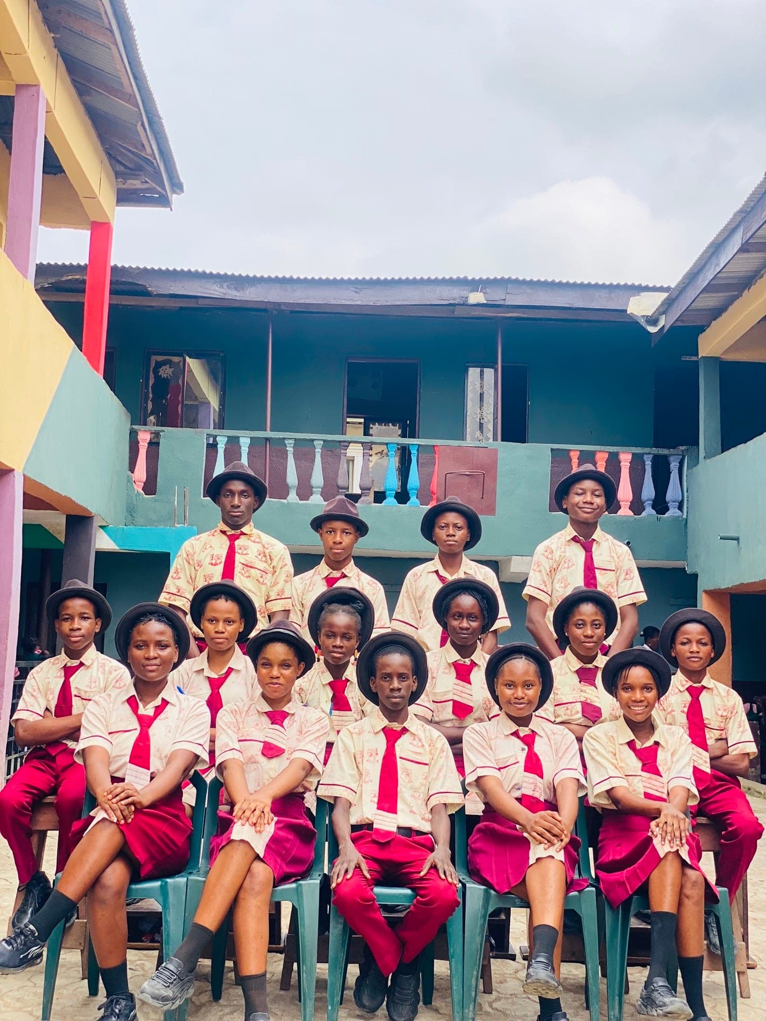 Senior secondary students in school uniform seated together in the courtyard