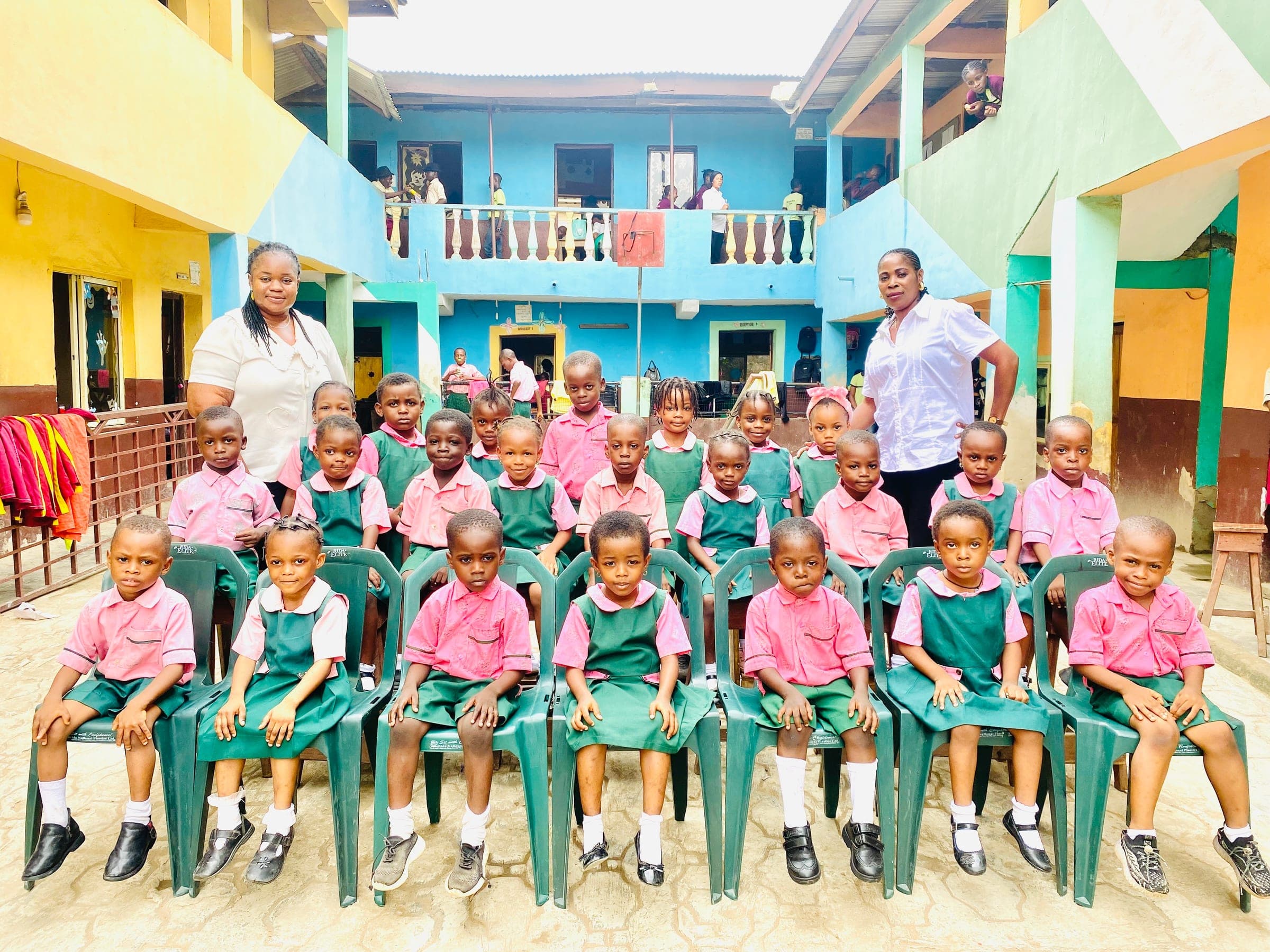 Nursery pupils with two teachers arranged for a class photograph in the courtyard